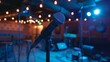 © Justlight - Microphone is positioned center stage in a small music venue illuminated by blue stage lights as it awaits the arrival of the performer
