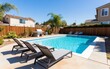 © chusnul - A sunny backyard pool with lounge chairs and a barbecue area, perfect for relaxation and leisure.
