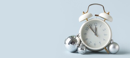 Alarm clock and decorations on light background with space for text. Christmas countdown concept