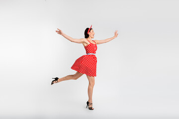 Full body photo of attractive woman dancing have fun enjoy holiday dressed red vintage style polka dot skirt isolated on white background