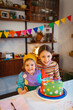 © Melissa Milis Photography/Stocksy - two happy girls at birthday table