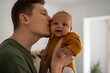 © Milles Studio/Stocksy - Loving father kissing his newborn baby