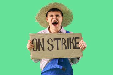 Wall Mural - Protesting male farmer holding placard with text ON STRIKE against green background