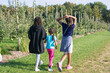 © Anya Brewley Schultheiss/Stocksy - Three children walking along the path at an apple orchard in summer