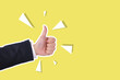 © TimmyTimTim - A hand giving a thumbs up on a yellow background. The thumbs up is a symbol of approval or agreement.