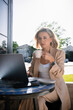 © DZ FILM/Stocksy - A woman uses a laptop sitting on a cafe terrace
