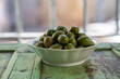 Spanish tapas, green andalusian olives with old Andalusian window bars and houses on background, Jerez de la Frontera, Andalusia, Spain