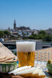 Spanish beer , cheese, tapas and green andalusian olives served on outdoor roof terrace with view on central part of old Sevilla, Andalusia, Spain