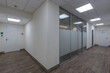 © alhim - A bright corridor of the wellness center with brown laminate flooring and many doors.