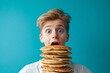 © robertuzhbt89 - A surprised young boy with wide eyes and an open mouth, holding a tall stack of pancakes in front of him.
