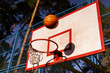 © Oleksii Syrotkin/Stocksy - Basketball going through hoop on outdoor playground in park