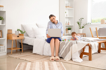 Poster - Young happy business mother working with laptop and little baby playing at home