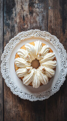 Wall Mural - Round cake with whipped cream topping decorated with roasted almonds on white plate on rustic wooden table