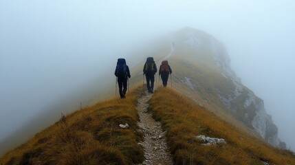 Poster - Three individuals equipped with hiking gear traverse a narrow path on a fog-covered mountain. The atmosphere is serene, with visibility reduced by the mist surrounding them.