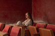 © Basil Pind/Stocksy - Woman Sitting in Sand-Filled Vintage Theater Seat