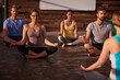 © peopleimages.com - Lotus, meditation or yogi with people in yoga class for chakra energy, therapy and inner peace in studio. Group, wellness and zen instructor in apartment for spiritual healing or calm mindfulness