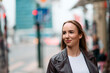 © Minet - Charming Woman Strolls Through City Streets Wearing a Fashionable Leather Jacket.