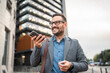 © Miljan Živković - Adult man businessman left voice message on mobile phone on the street