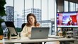 © DC Studio - Pleased confident business leader signing along to her favorite songs, multitasking while she works on her career development goals. Young woman having fun with music in high end office. Camera B.