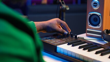 Leinwandbilder - Music engineer producing song by mixing and mastering tunes on audio console, playing piano notes on synthesizer to record sounds on pc. Producer creating soundtracks with midi controller. Camera A.