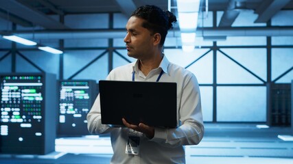 Poster - technician using laptop in data center, managing servers, operating systems. professional in server 