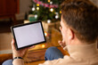 © wavebreak3 - senior man video chatting on tablet by Christmas tree at home, copy space