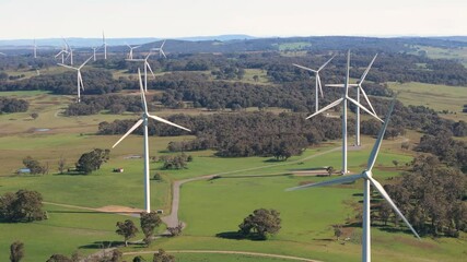 Wall Mural - aerial drone pullback reverse view of an array of large wind turbines at biala and gullen range wind