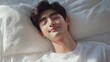 © Gophotograph - The tranquility of a 20-year-old man resting comfortably on a white bed.