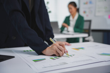 Businesswoman is analyzing financial charts and making an investment strategy in the office