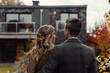 © OMGAi - Young married couple enjoying moment together while choosing their new home, surrounded by autumn colors and modern house. Their connection is evident in this serene setting