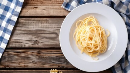 Top view of pasta cooking setup on wooden table with empty plate