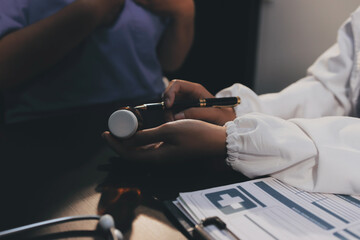 Senior woman holding medicine bottle with nurse using laptop at home