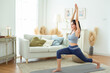 © tonefotografia - Asian woman in sportswear exercising and doing yoga in living room at home.