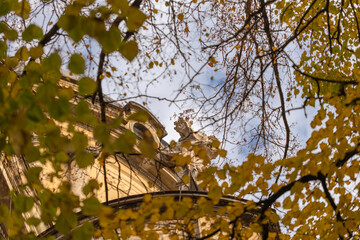 Wall Mural - View on Lviv through autumn leaves