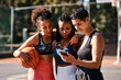 © peopleimages.com - Basketball, friends and women with phone for sports schedule, social media or show results on chat app. Mobile, ball or group of girls outdoor on break after training, fitness or online game on court