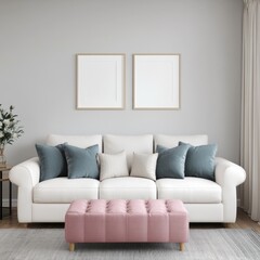 A white sofa with blue and white pillows in front of a grey wall with two empty picture frames. A pink tufted ottoman sits in front of the sofa.