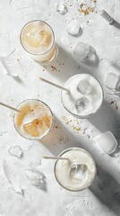   A collection of beverages resting atop a table alongside two glasses brimming with liquid and ice