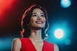 © Maelgoa - A young Asian businesswoman in a bold red dress proudly accepting an award on stage, bright lights shining on her smiling face, medium close-up showing her excitement and pride 2