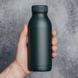 © PuiZera - Hand holding a black reusable water bottle.