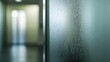 © Watanabe - A close-up shot of a frosted glass door with condensation, blurring the hallway behind.