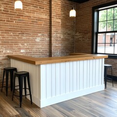 Modern white bar counter with wood top in a loft style interior with brick wall and hardwood floors.