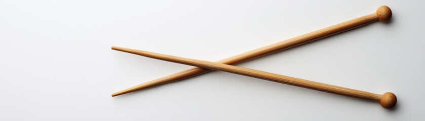 Poster - Two Wooden Knitting Needles Crossed on White Background