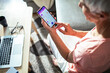 © Marko Geber - Close up senior woman checking bank account balance on smartphone app at home