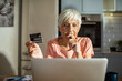 © Marko Geber - Senior woman making an online purchase with credit card at home