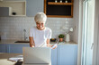 © Marko Geber - Senior woman working on laptop at home