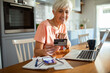 © Marko Geber - Senior woman making an online purchase with credit card at home