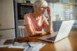 © Marko Geber - Senior woman working on laptop at home