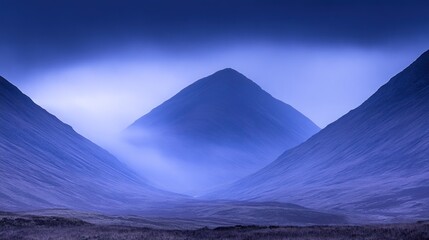 A misty valley shrouded in blue light, with two towering mountains on either side.