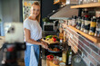 © Geber86 - Young woman filming cooking tutorial in kitchen with fresh vegetables and eggs