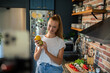 © Geber86 - Young woman filming cooking tutorial in kitchen with fresh vegetables and eggs